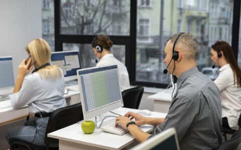 colleagues-working-together-call-center-with-headphones